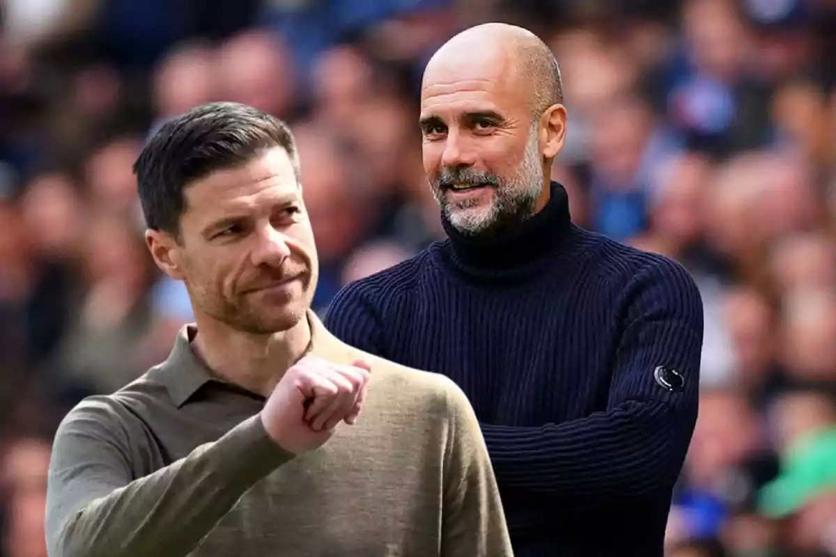 Dos entrenadores de fútbol posan en un estadio lleno de espectadores