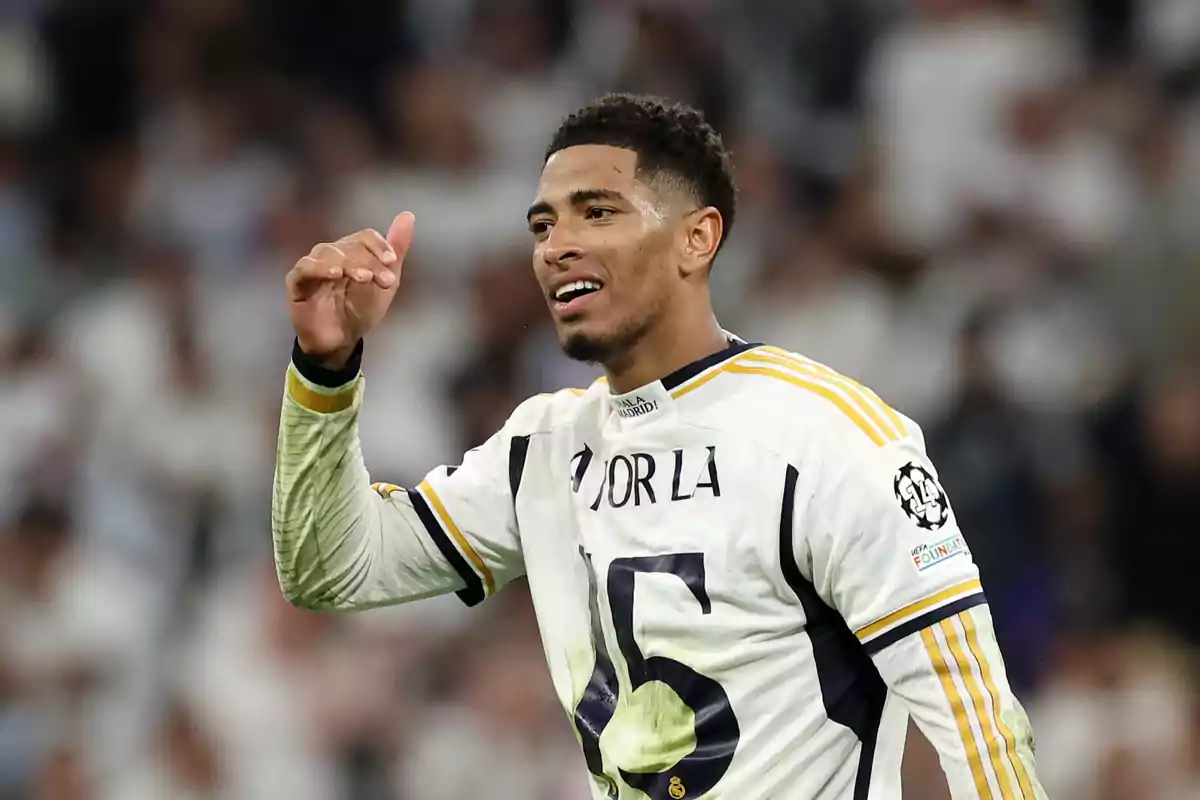 Un jugador de fútbol con la camiseta del Real Madrid celebrando en el campo.