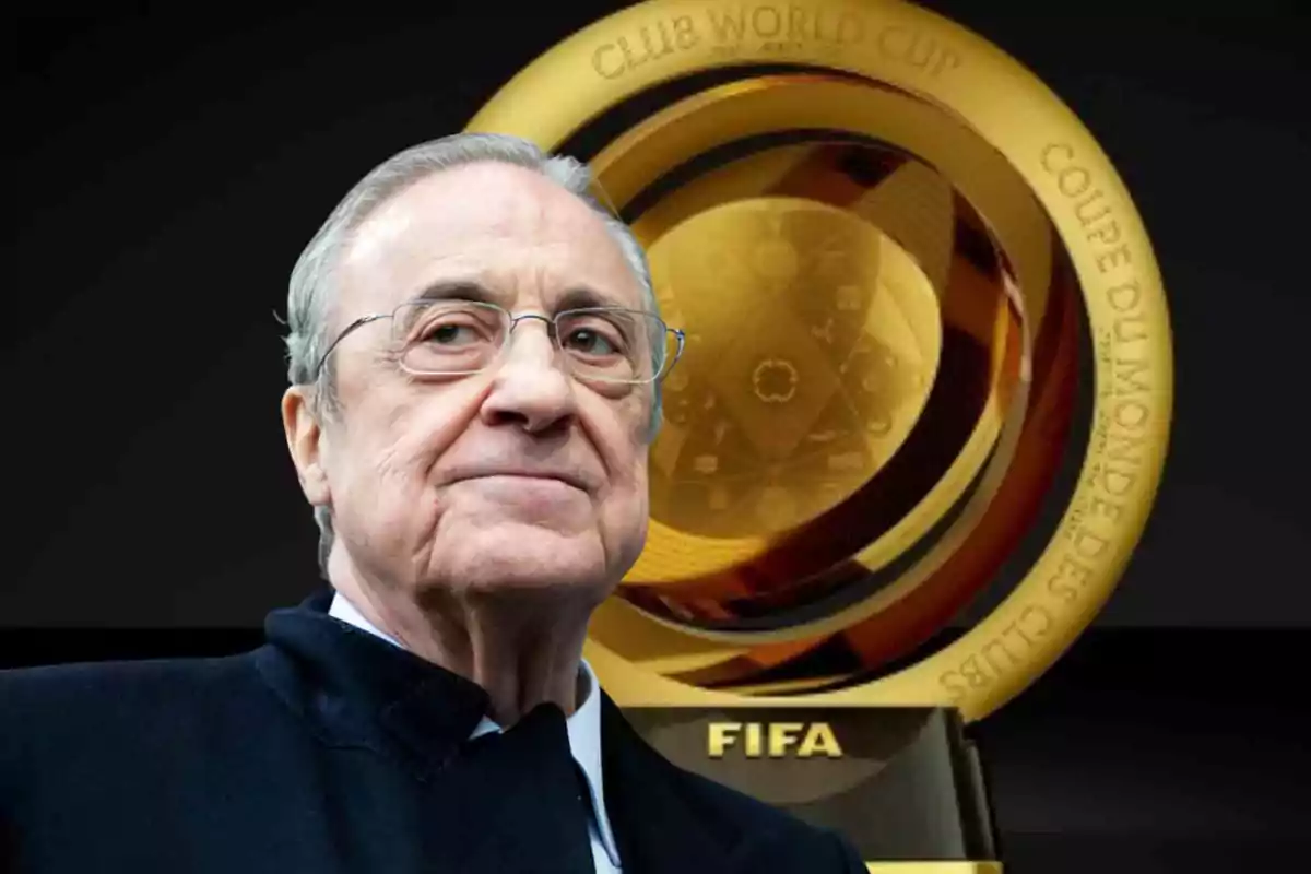 Un hombre mayor con gafas y cabello canoso está frente a un trofeo dorado de la Copa Mundial de Clubes de la FIFA.