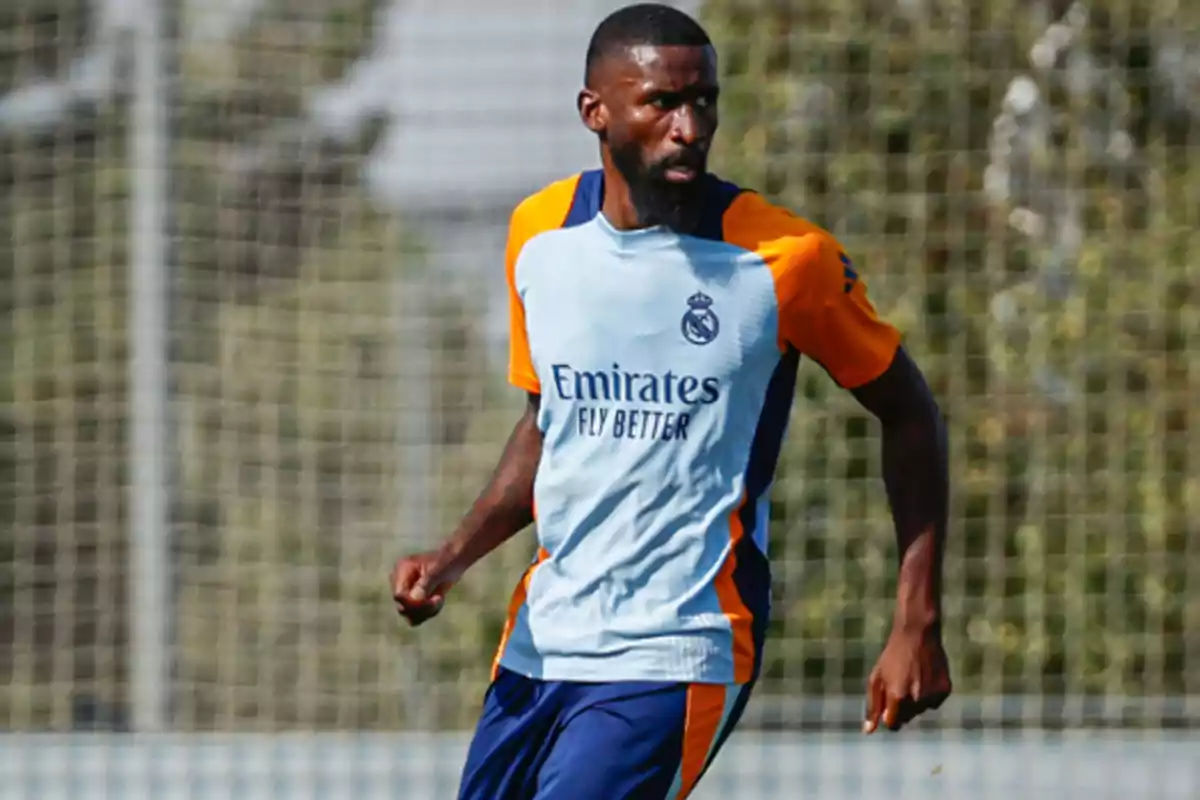 Un jugador de fútbol con uniforme de entrenamiento del Real Madrid en el campo.