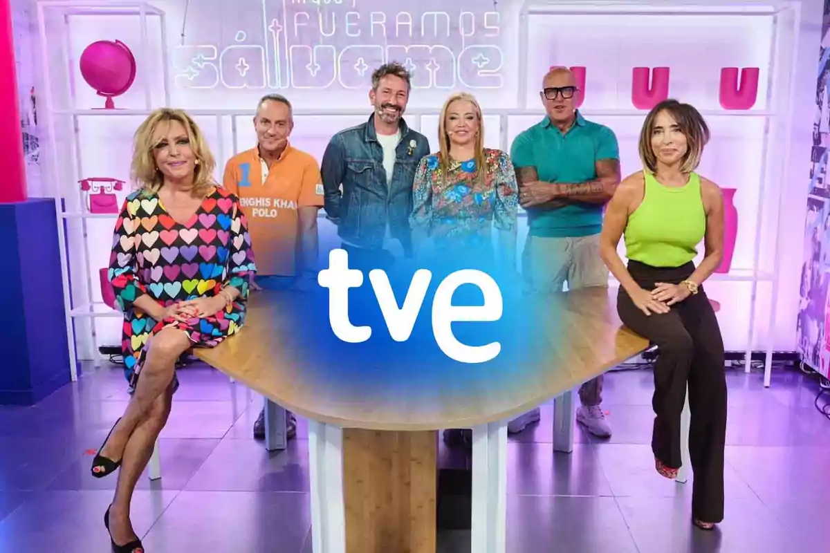 Un grupo de personas posando en un set de televisión con un logotipo de "tve" en el centro.