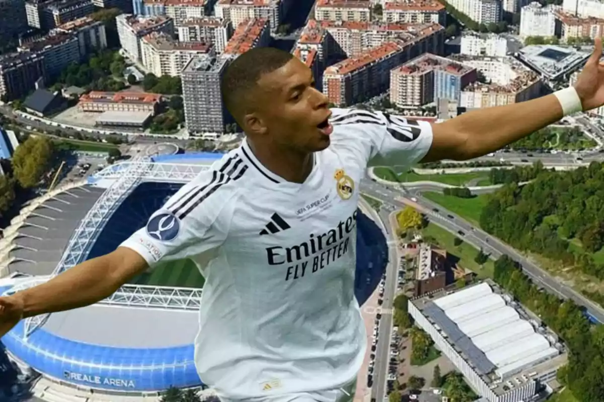 Un jugador de fútbol con la camiseta del Real Madrid celebra un gol con los brazos extendidos, con un estadio y una ciudad de fondo.