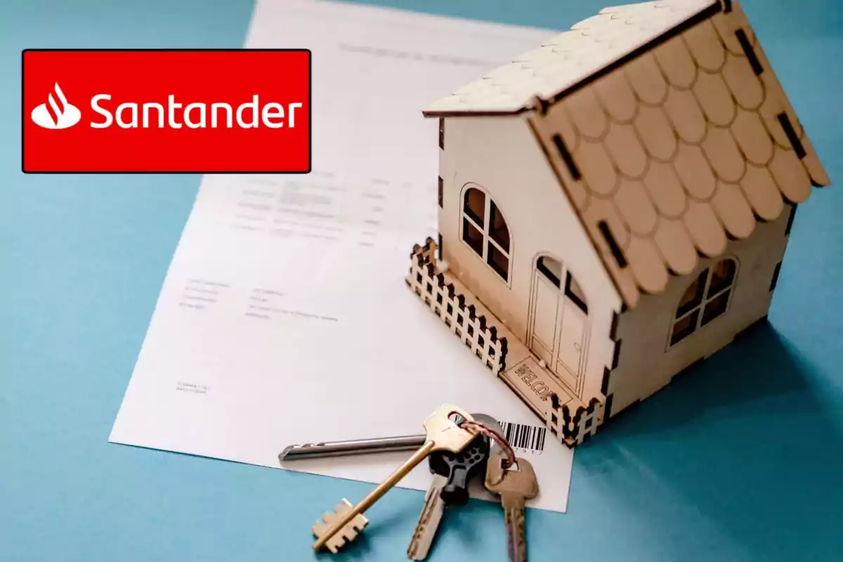 Casa en miniatura con llaves y documentos sobre una mesa, junto al logotipo de Santander.