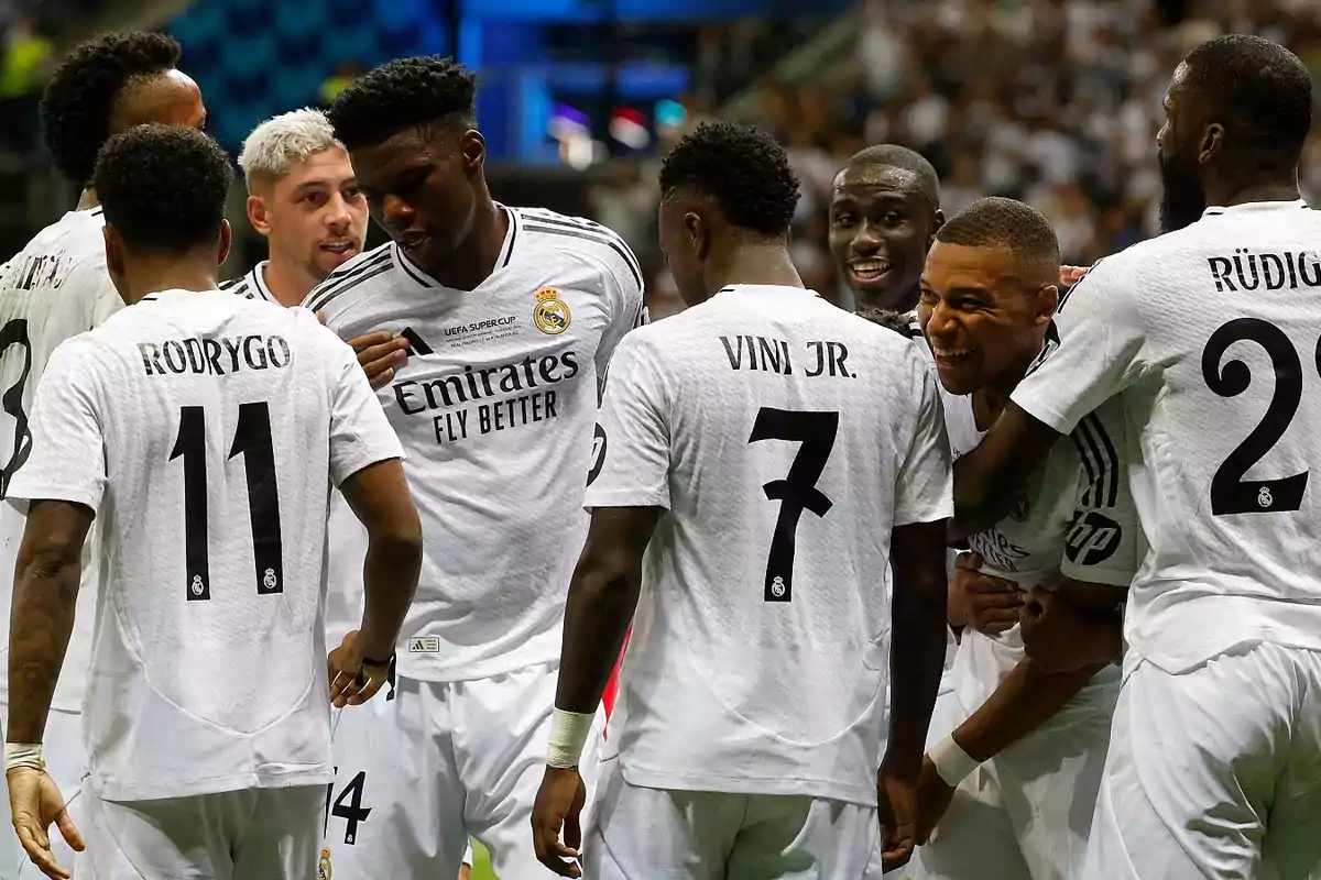 Jugadores del Real Madrid celebrando en el campo con sus uniformes blancos.