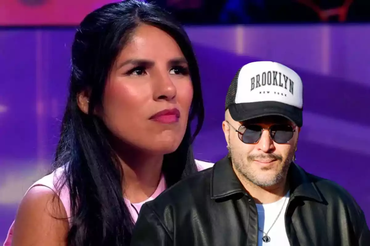 Una mujer con expresión seria y un hombre con gafas de sol y gorra que dice "Brooklyn" posan frente a un fondo púrpura.