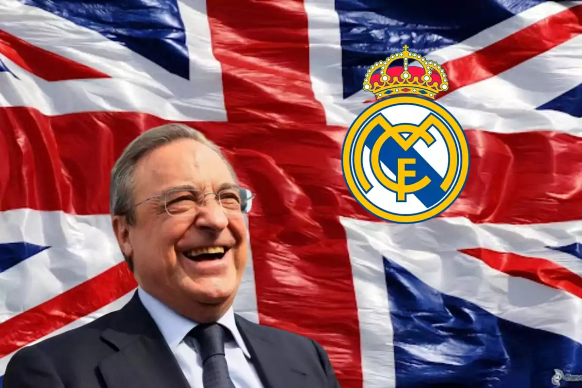 Un hombre sonriente con gafas y traje frente a una bandera del Reino Unido y el escudo del Real Madrid.