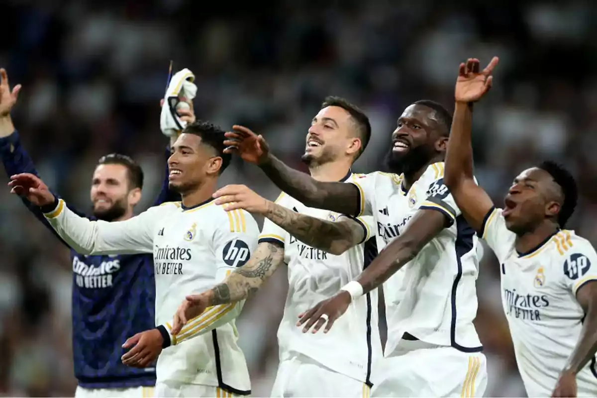 Jugadores de fútbol del Real Madrid celebrando en el campo.