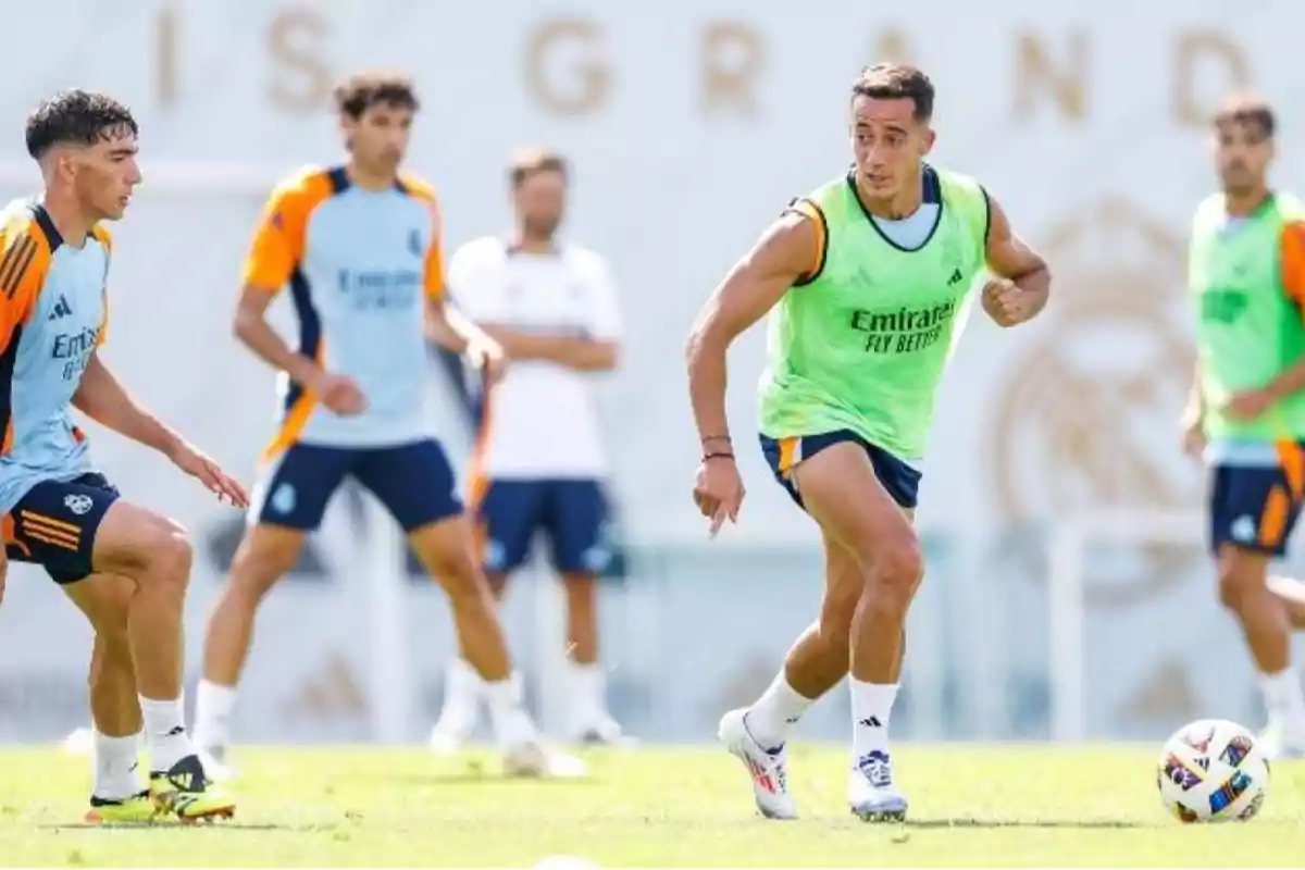 Jugadores de fútbol entrenando en un campo de entrenamiento con uniformes de práctica.