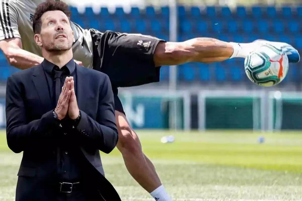 Un hombre con traje negro está en primer plano con las manos juntas en actitud de oración, mientras que en el fondo se ve a un jugador de fútbol realizando una acrobacia con el balón en un campo de entrenamiento.