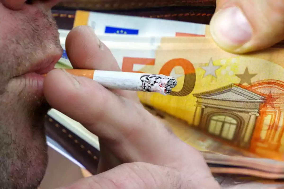 Un hombre sosteniendo un cigarrillo encendido cerca de su boca con billetes de euro en el fondo.