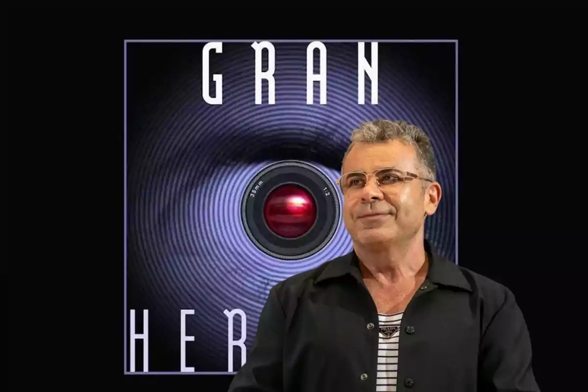 Un hombre con gafas y una chaqueta oscura está de pie frente a un logotipo que dice "Gran Hermano" con un diseño de ojo y una lente de cámara en el centro.