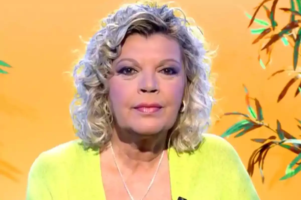Mujer de cabello rubio rizado y corto con suéter amarillo claro posando frente a un fondo naranja con hojas decorativas Mujer de cabello rubio rizado y corto con suéter amarillo claro posando frente a un fondo naranja con hojas decorativas
