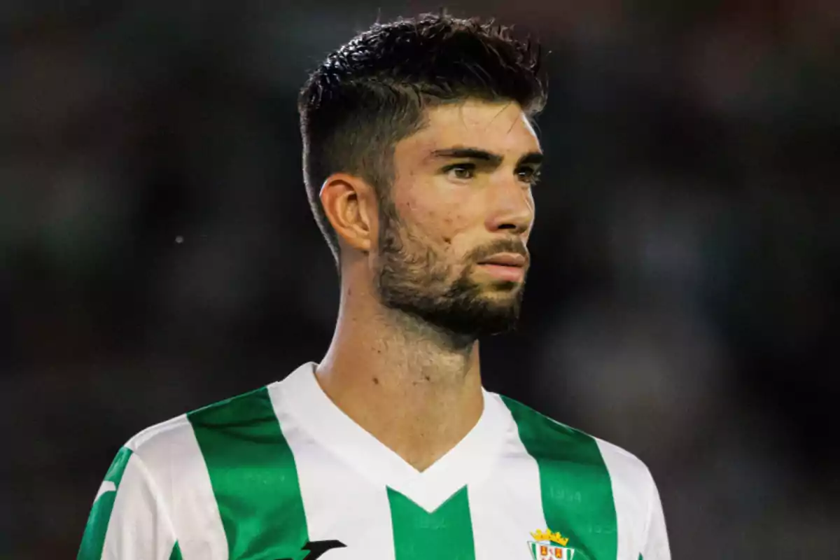 Un jugador de fútbol con uniforme verde y blanco en el campo. Un jugador de fútbol con uniforme verde y blanco en el campo.