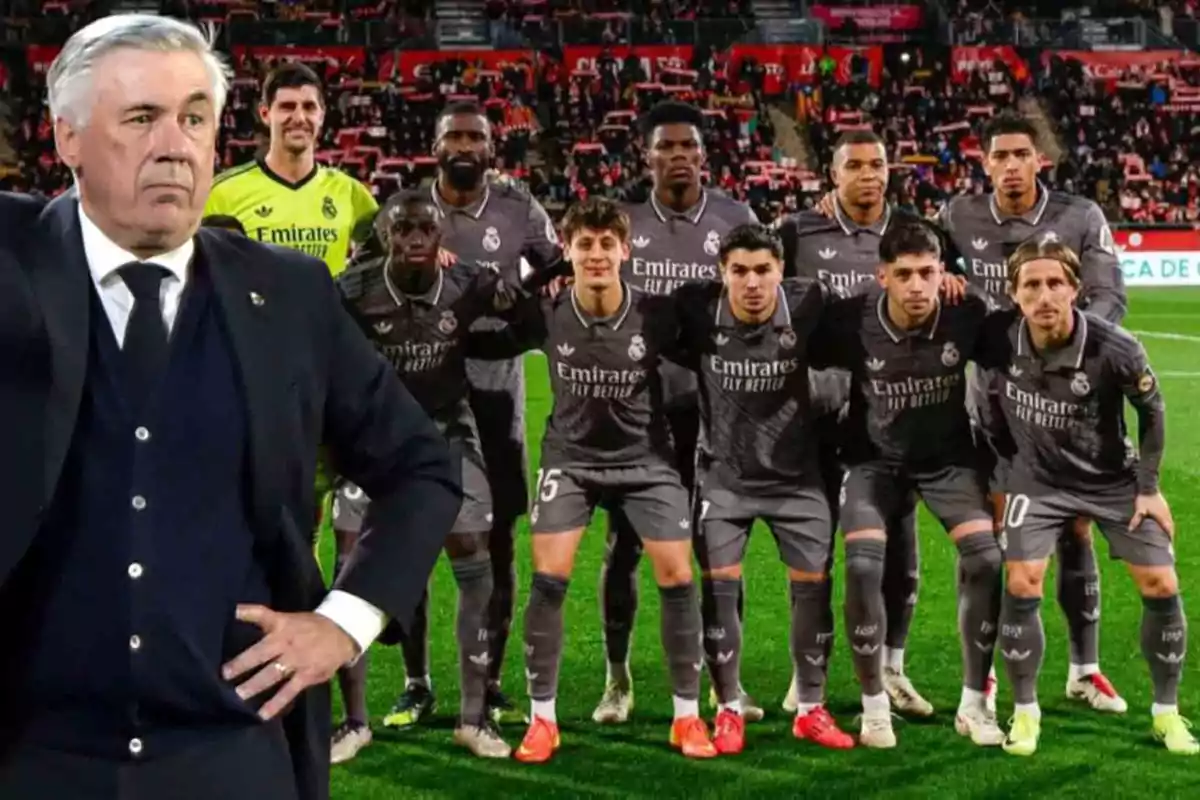 Un entrenador de fútbol está de pie en el campo mientras un equipo de jugadores posa para una foto grupal antes de un partido.