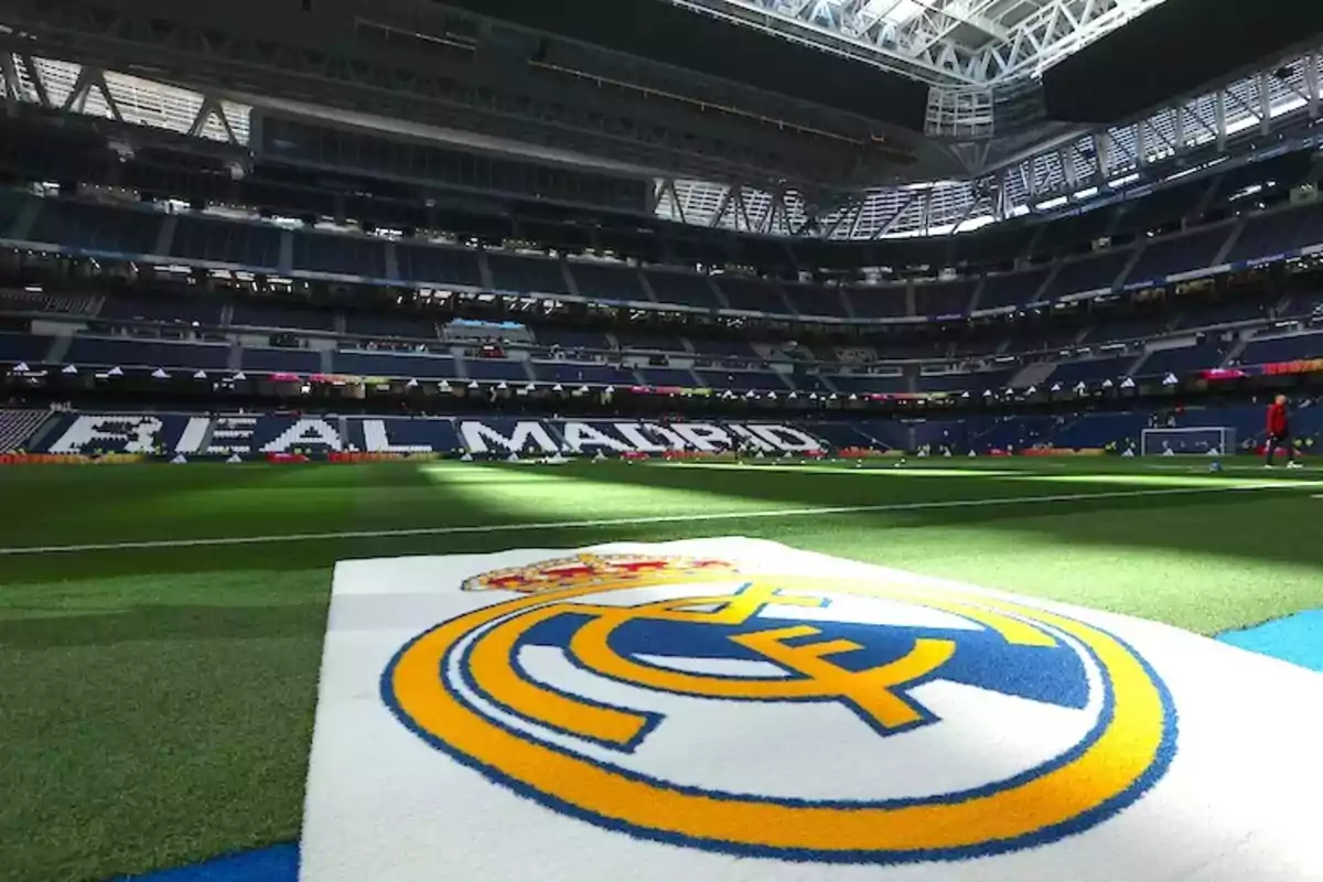 Estadio de fútbol del Real Madrid con el escudo del equipo en primer plano.