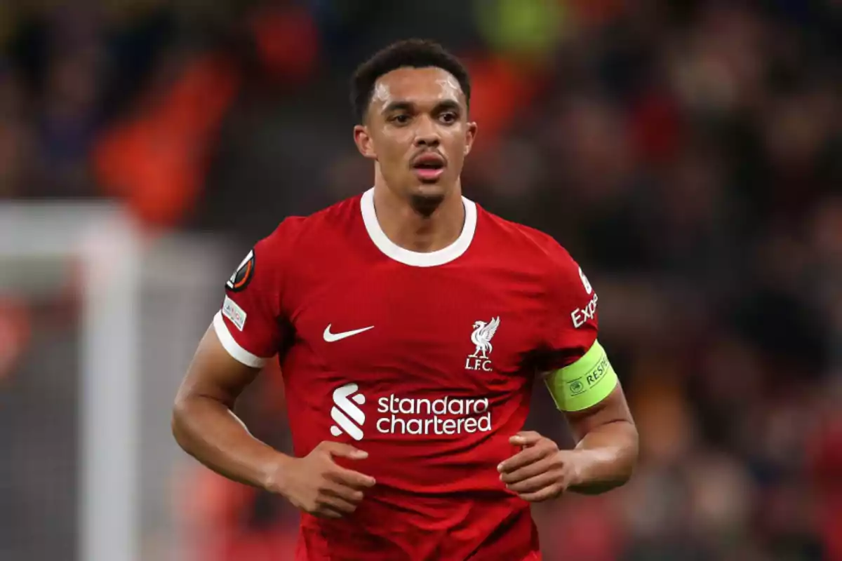 Jugador de fútbol con uniforme rojo del Liverpool FC en el campo de juego.