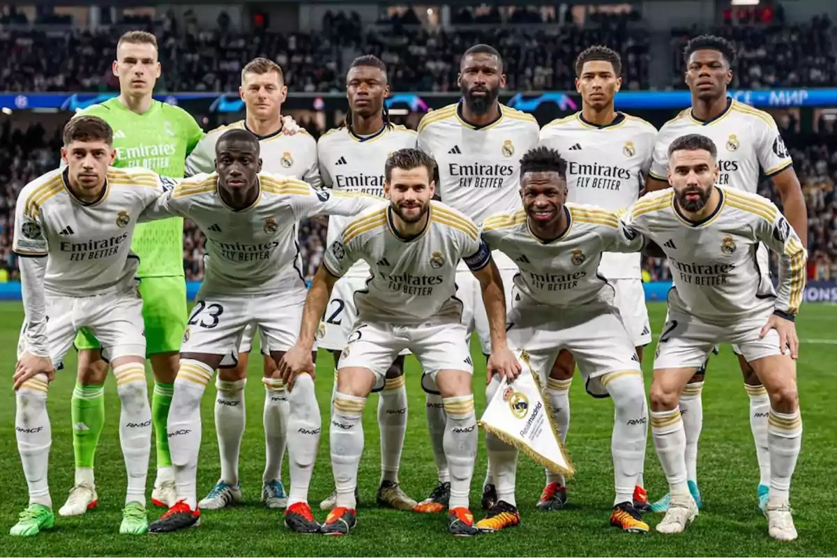 Jugadores de fútbol del Real Madrid posando para una foto de equipo en el campo.