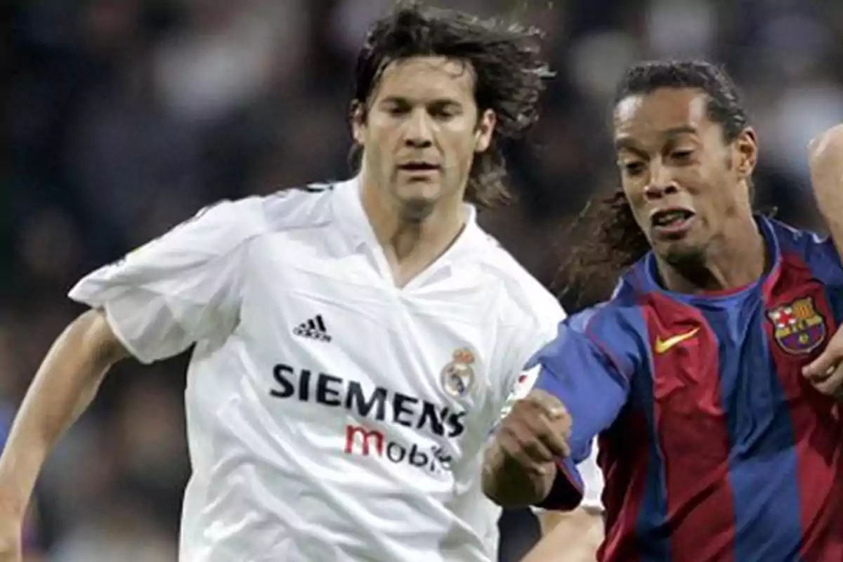 Dos futbolistas compitiendo por el balón durante un partido de fútbol.