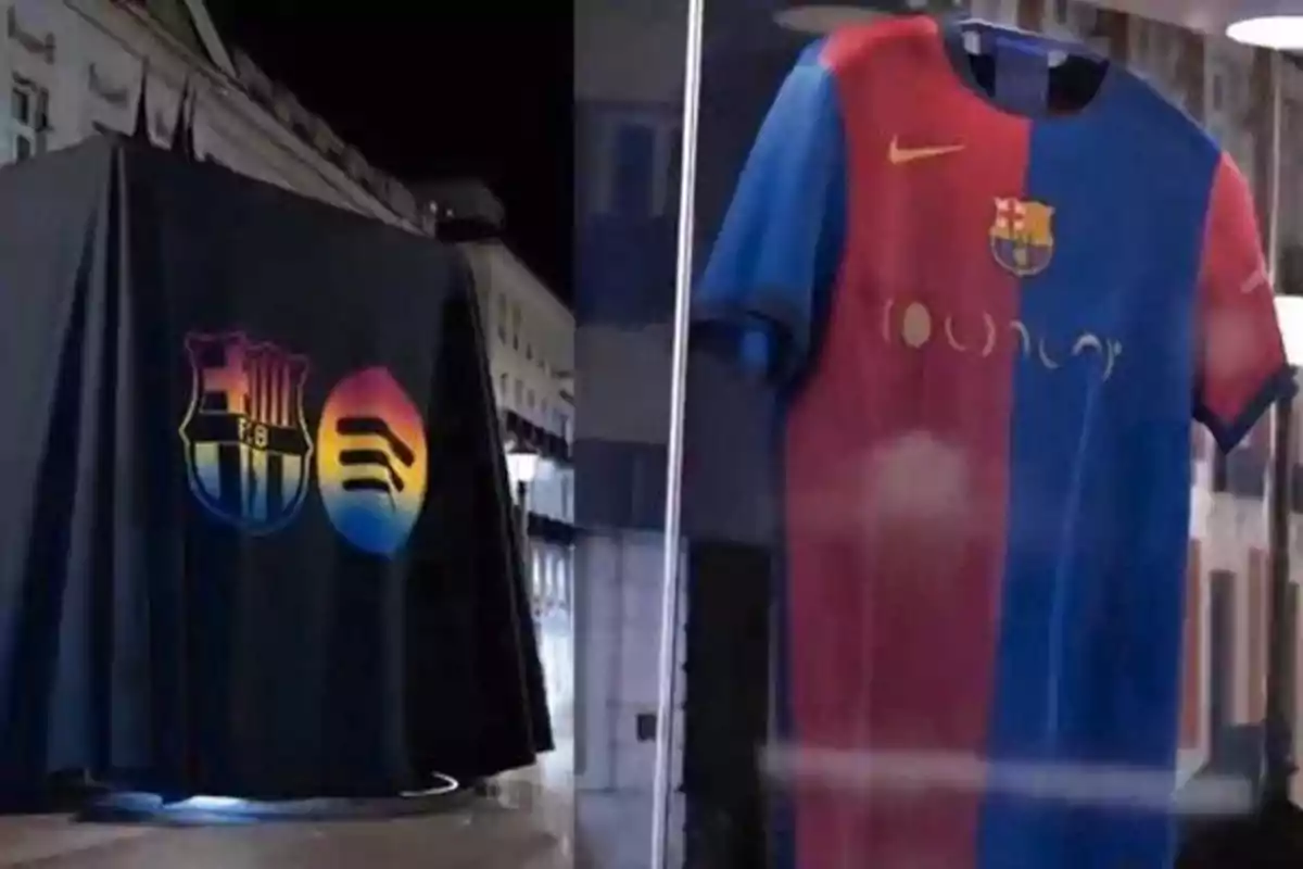 Una camiseta de fútbol azul y roja con logotipos en una vitrina junto a una tela negra con emblemas de colores.