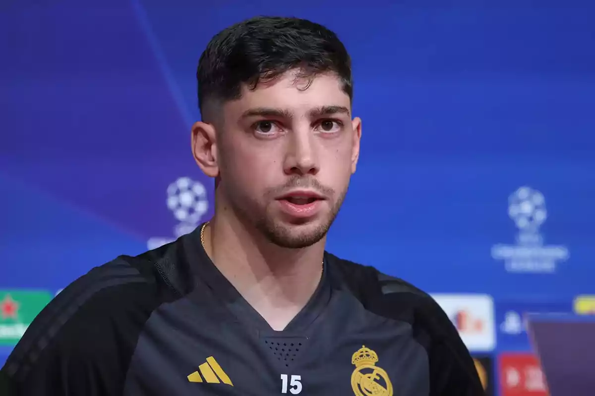 Un jugador de fútbol del Real Madrid en una conferencia de prensa con un fondo azul.