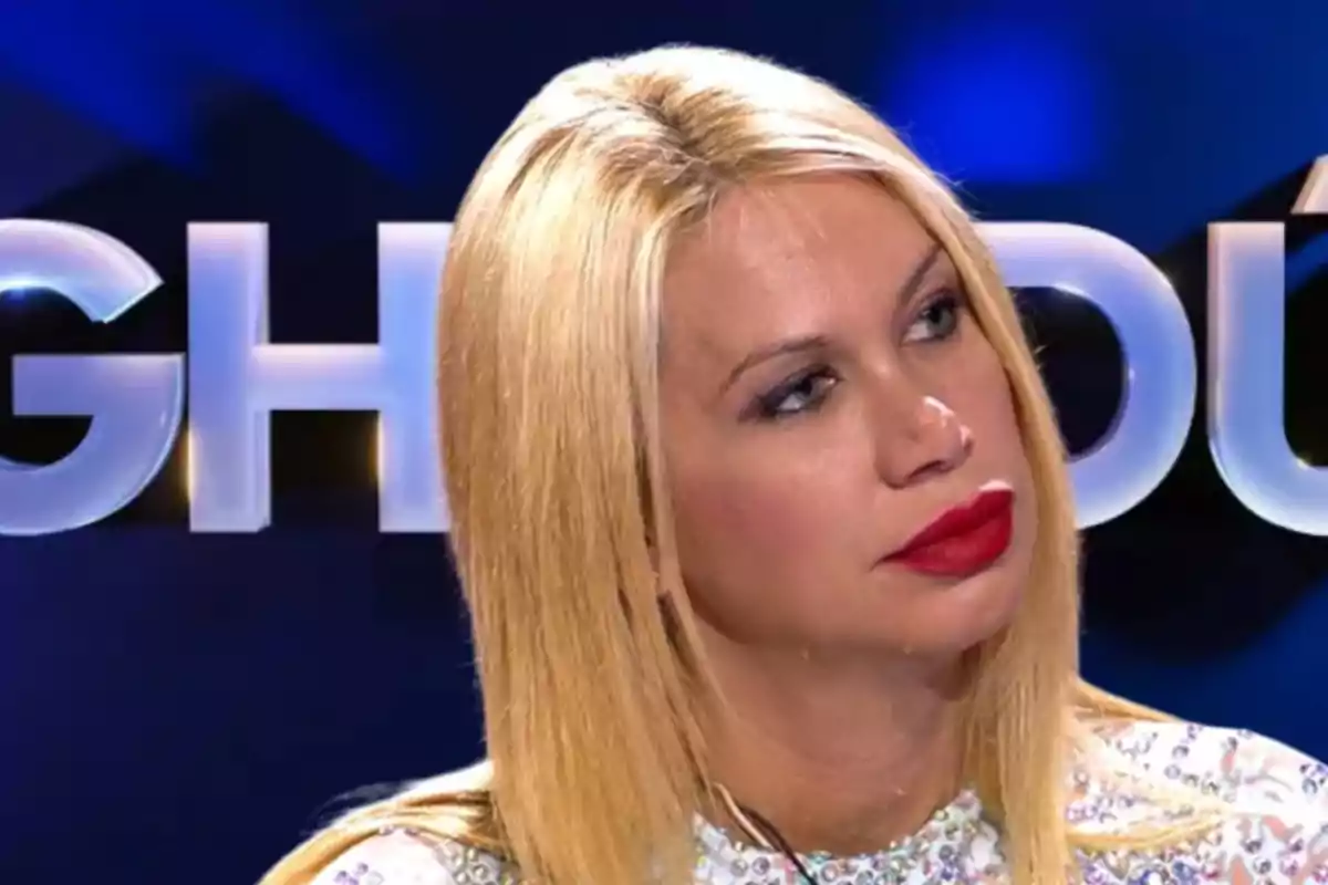 Mujer rubia con labios rojos en un programa de televisión.