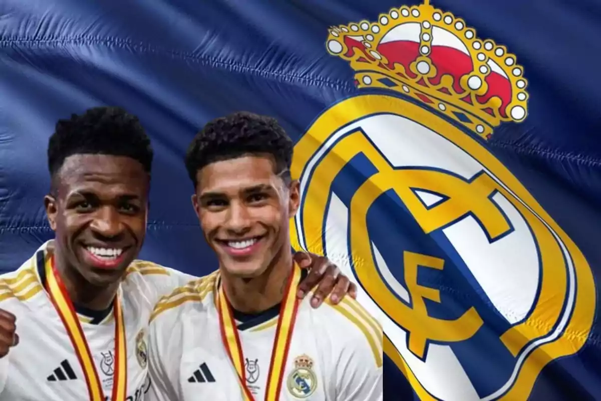 Dos jugadores del Real Madrid posando frente a una bandera del equipo.