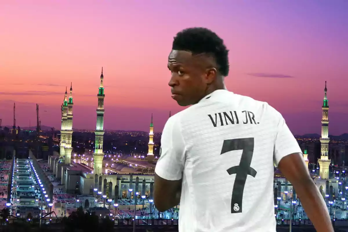 Un jugador de fútbol con la camiseta número 7 está de espaldas frente a un paisaje urbano al atardecer con minaretes iluminados.