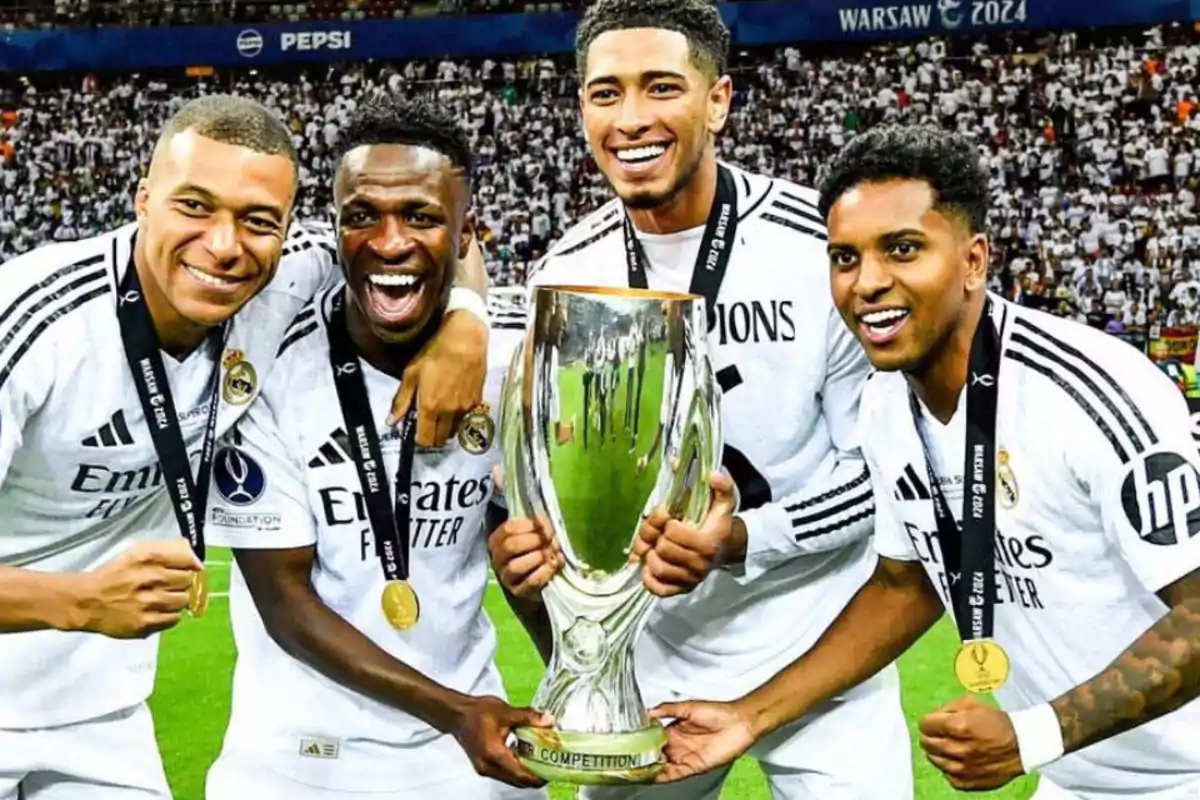 Jugadores del Real Madrid celebrando con un trofeo en el campo de fútbol.