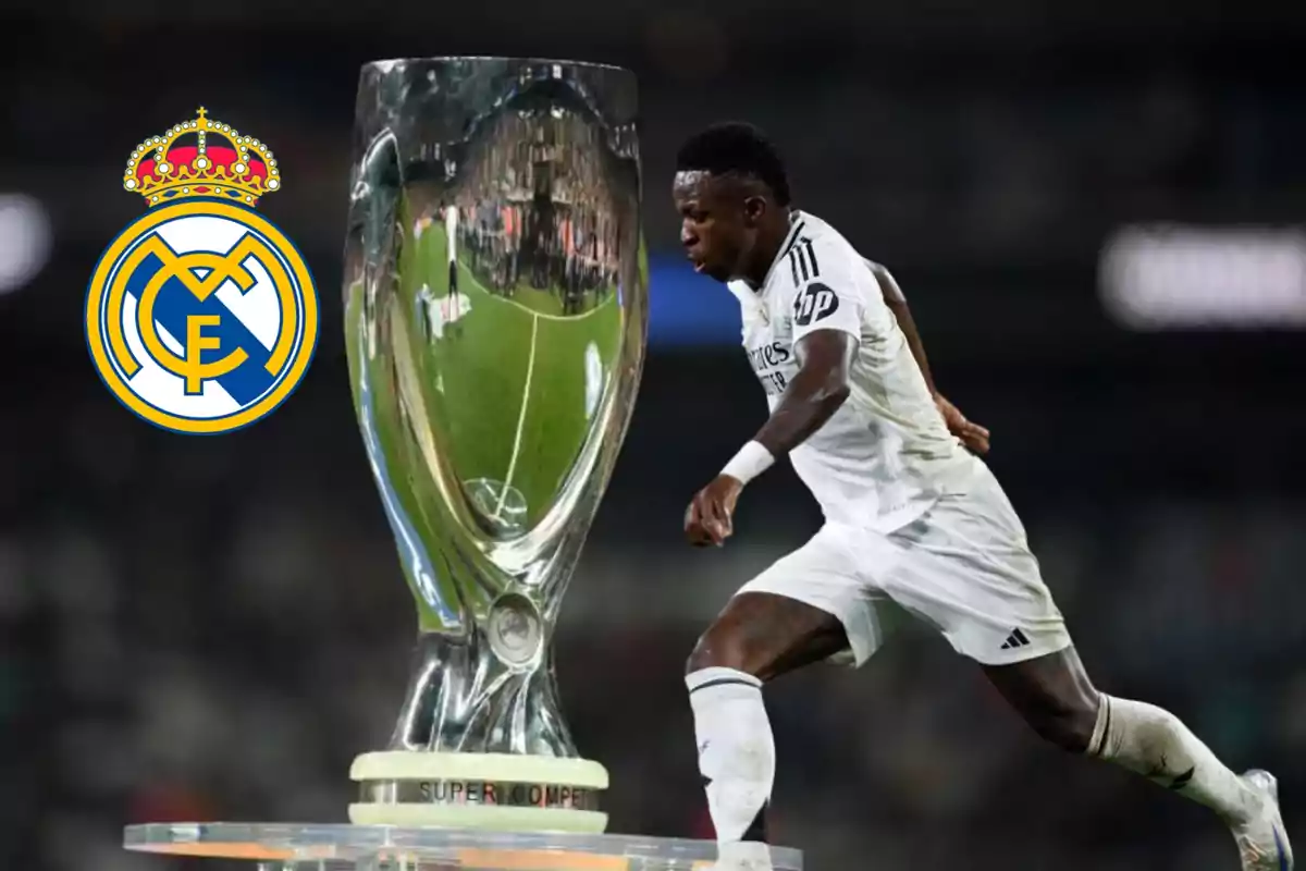 Un jugador de fútbol del Real Madrid corriendo junto a un trofeo con el logo del club en el fondo.