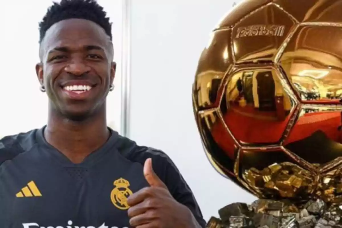 Vinicius Júnior sonriendo junto a un trofeo dorado.