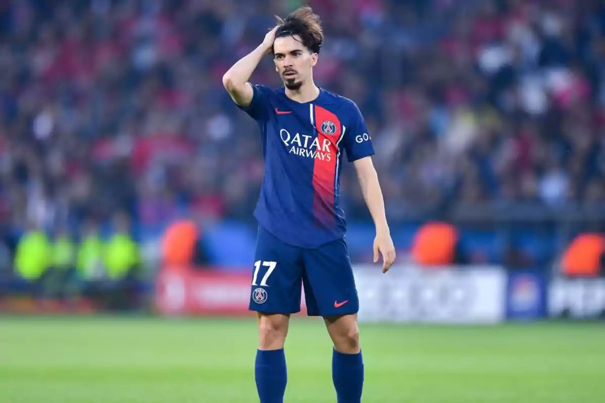 Un jugador de fútbol con el uniforme del PSG se toca la cabeza durante un partido. Un jugador de fútbol con el uniforme del PSG se toca la cabeza durante un partido.