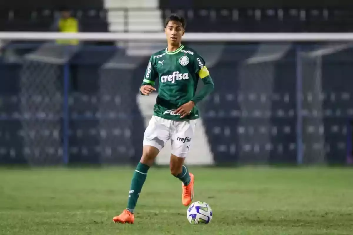 Jugador de fútbol con uniforme verde y blanco en el campo de juego.