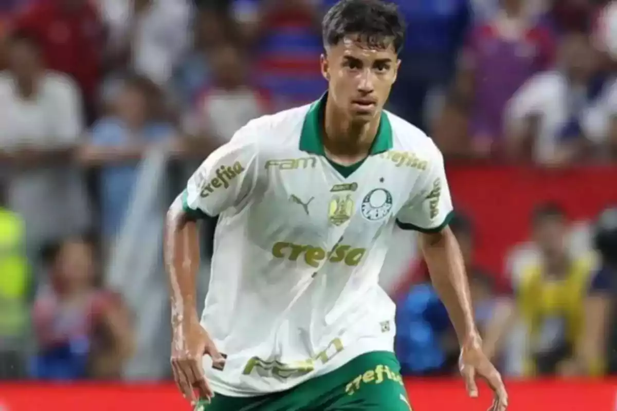 Jugador de fútbol con uniforme blanco y verde del Palmeiras en acción durante un partido.