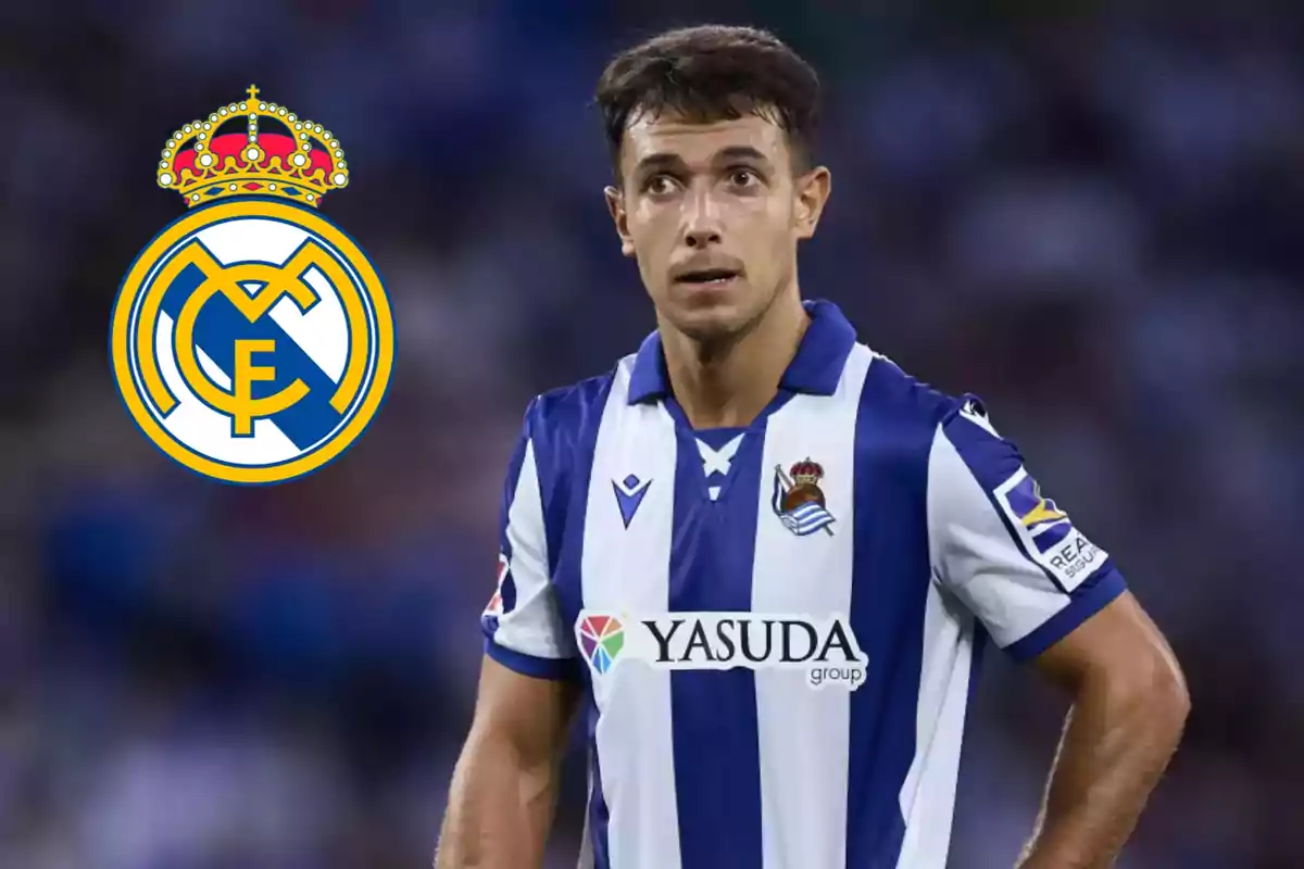 Jugador de fútbol con uniforme de la Real Sociedad junto al escudo del Real Madrid.